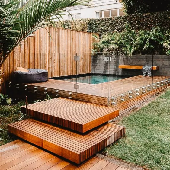 Wooden deck with a modern pool surrounded by a glass fence