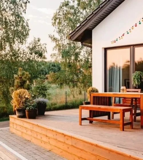 Grand patio en bois avec coin repas extérieur.