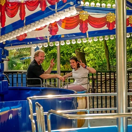 Manège coloré à Santa's Village avec des visiteurs souriants