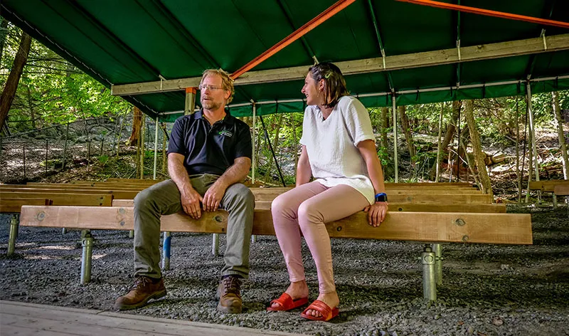 Professeur Rob et une invitée assis sur des bancs solidement installés sur des pieux vissés