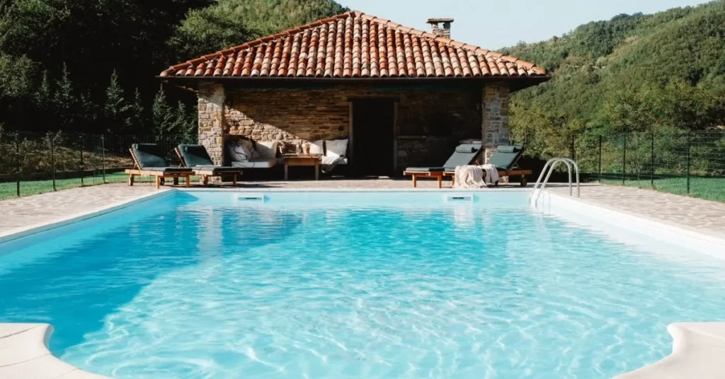 Piscine avec pavillon extérieur entouré de verdure.