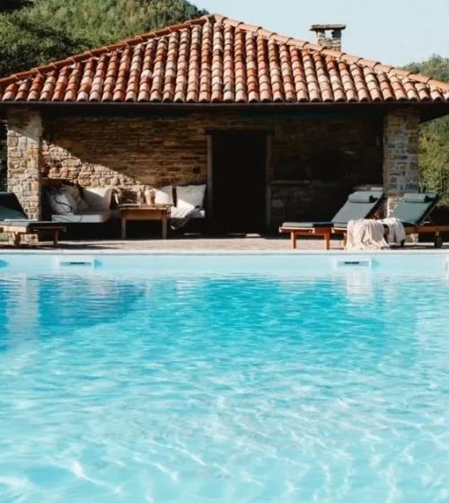 Piscine avec pavillon extérieur entouré de verdure.