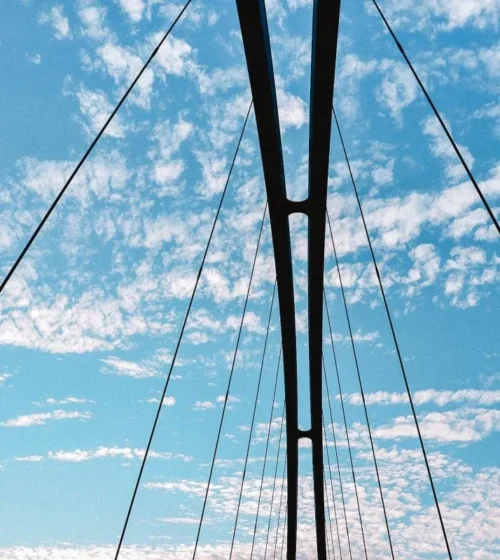 Câbles de tension d'un pont sous un ciel bleu.