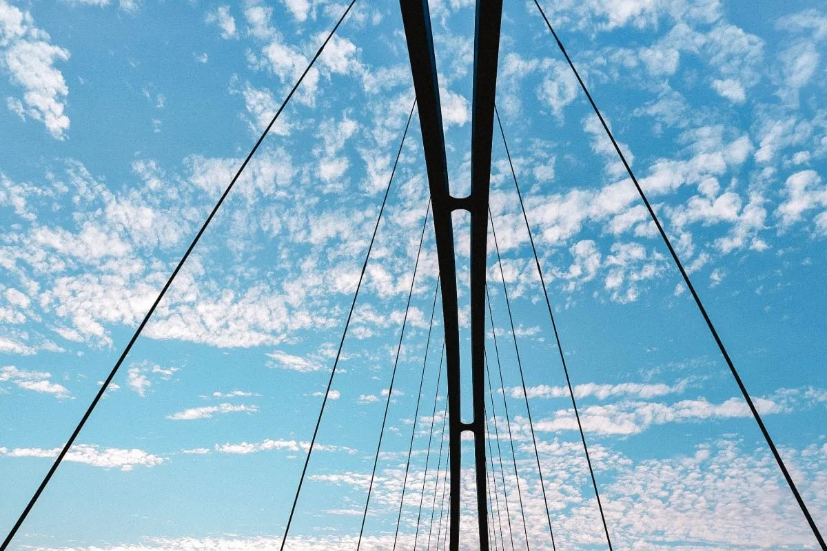 Câbles de tension d'un pont sous un ciel bleu.