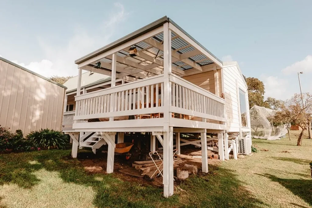 Elevated backyard deck with storage space underneath, showcasing yard preparation for winterizing screw piles.