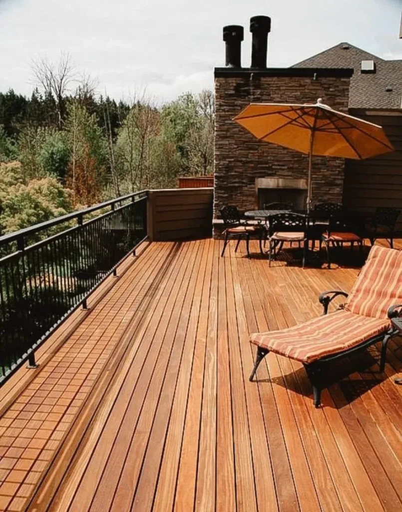 Modern wooden deck with lounge chair, umbrella, and forest view