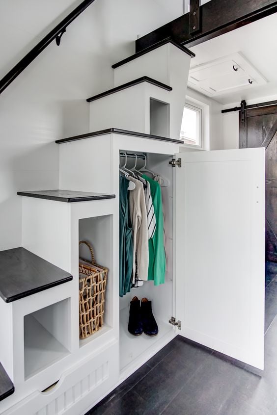 Rangement sous les escaliers dans une mini-maison sur pieux vissés.