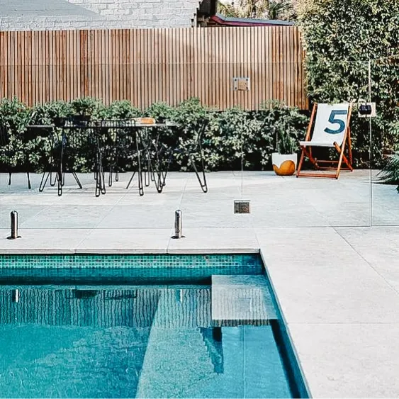 Terrasse moderne au bord de la piscine avec un design minimaliste et un coin salon extérieur