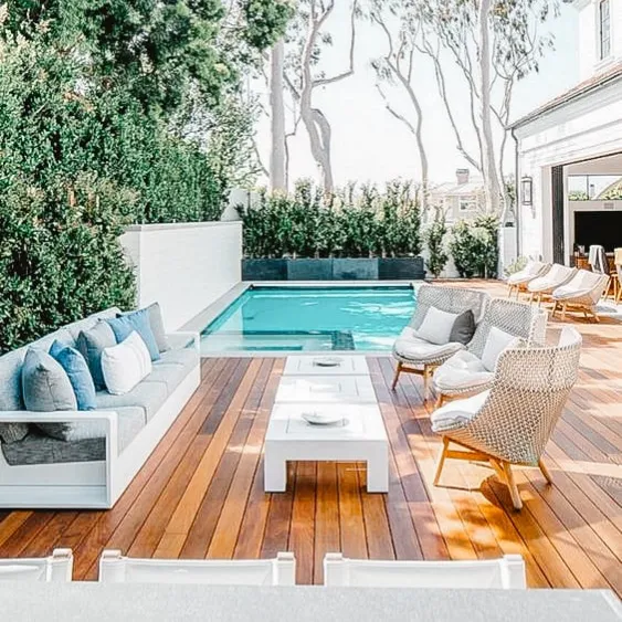 Terrasse de luxe au bord de la piscine avec mobilier extérieur moderne et verdure luxuriante