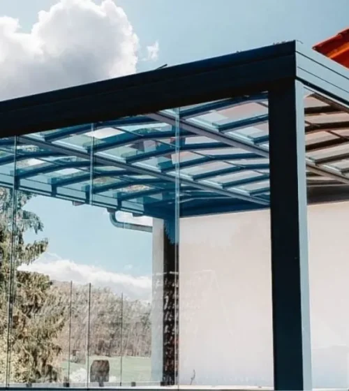 Solarium moderne avec des murs en verre et une structure noire élégante.