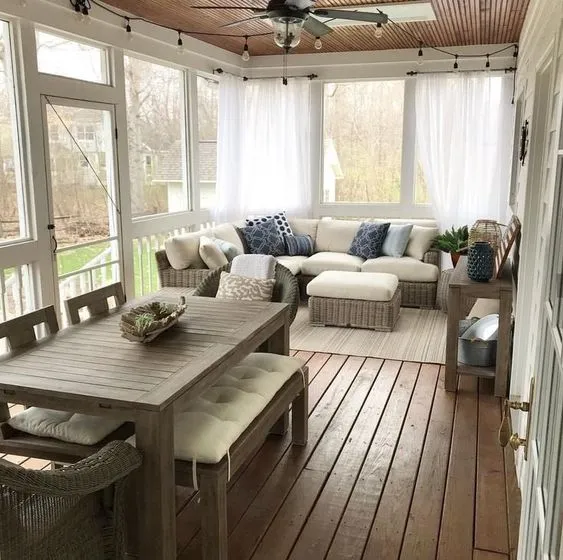 Cozy sunroom with wooden furniture, comfortable sofa, and natural light.