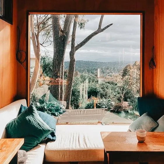 Cozy seating nook with a large window offering a stunning view of nature and greenery.