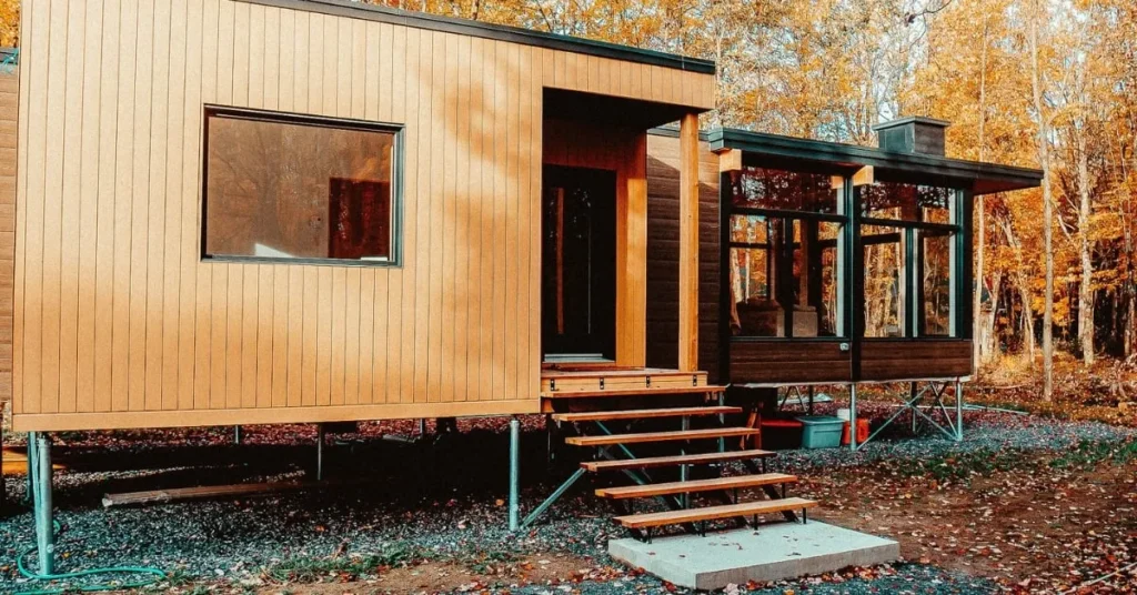 Modern cabin in the woods supported by screw piles.