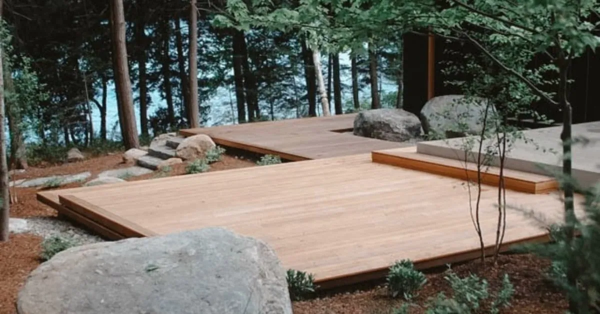 Terrasse basse en bois entourée de nature et de rochers