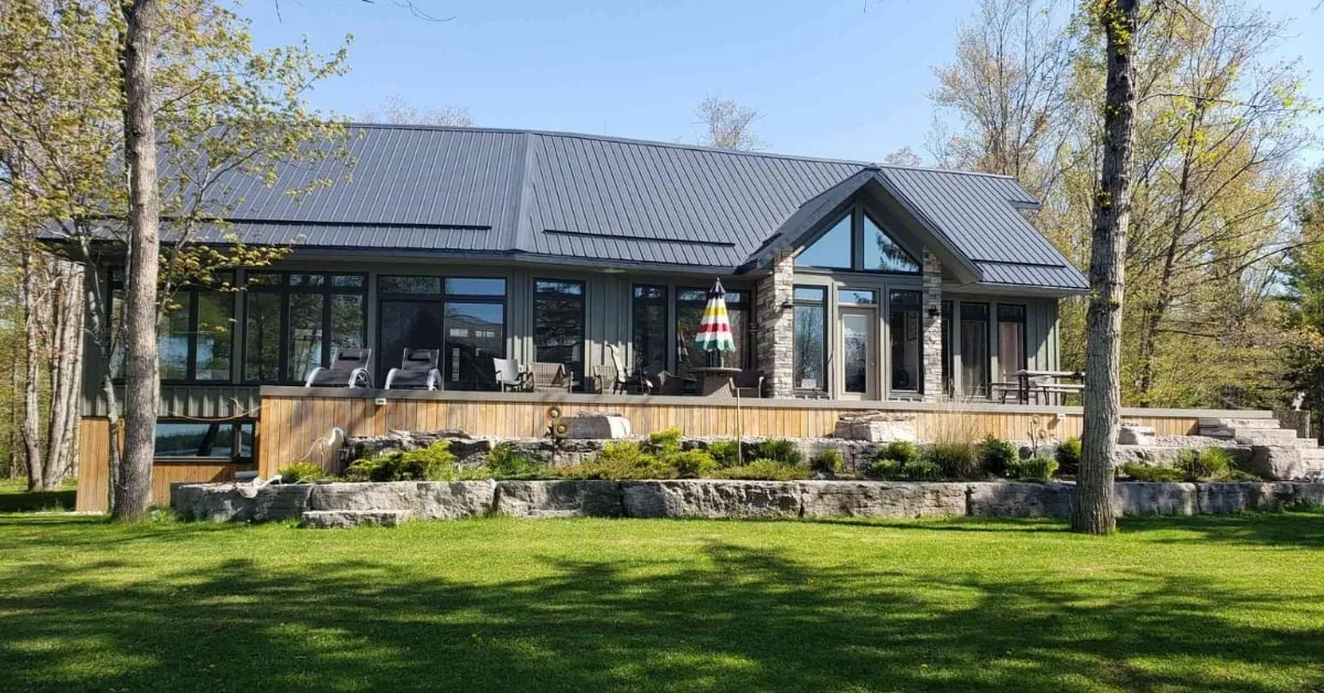 Maison de campagne moderne avec une terrasse spacieuse, soutenue par des pieux vissés solides, idéale pour des projets d'agrandissement fiables.