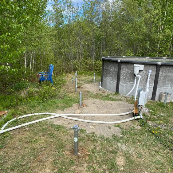 Pool area with screw piles installed, preparing for a deck transformation.