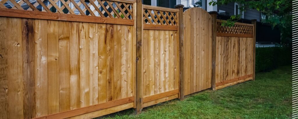 Wooden privacy fence with robust Postech Screw Piles foundation in a backyard