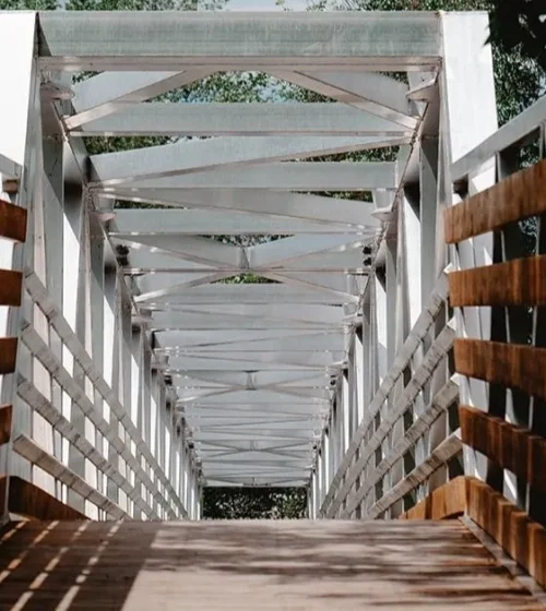 Promenade en bois soutenue par des pieux vissés écologiques.