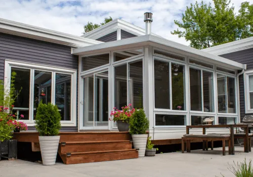 Maison moderne avec solarium et véranda, soutenue par des pieux vissés Vistech pour une base solide et durable.