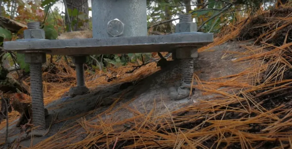 Pieu vissé Vistech installé sur une surface rocheuse, fixée solidement avec des boulons